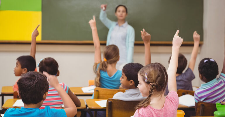 Teacher asking a question to her class at the elementary school